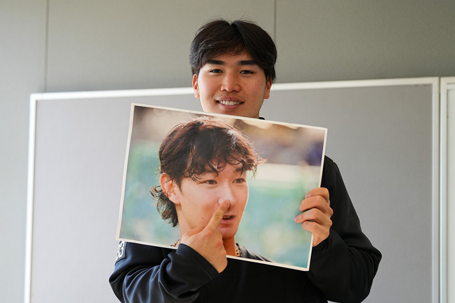 正木智也の写真ボードを指さす廣瀬隆太【写真：冨田成美】