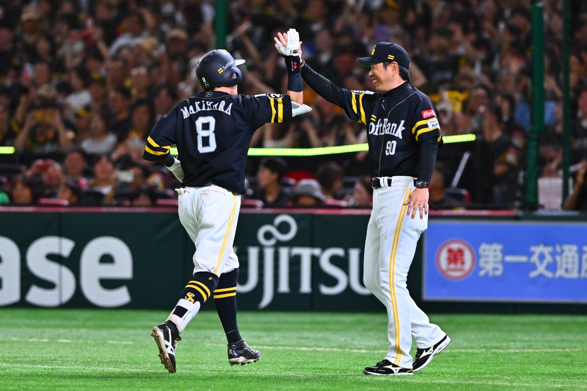 小久保裕紀監督とハイタッチする牧原大成【写真：古川剛伊】