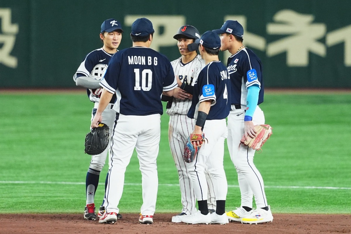 韓国選手と二塁ベース上で会話を交わす野村勇【写真：小林靖】