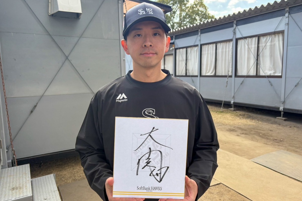 新しいサインを書いた色紙を持つ大関友久【写真：森大樹】