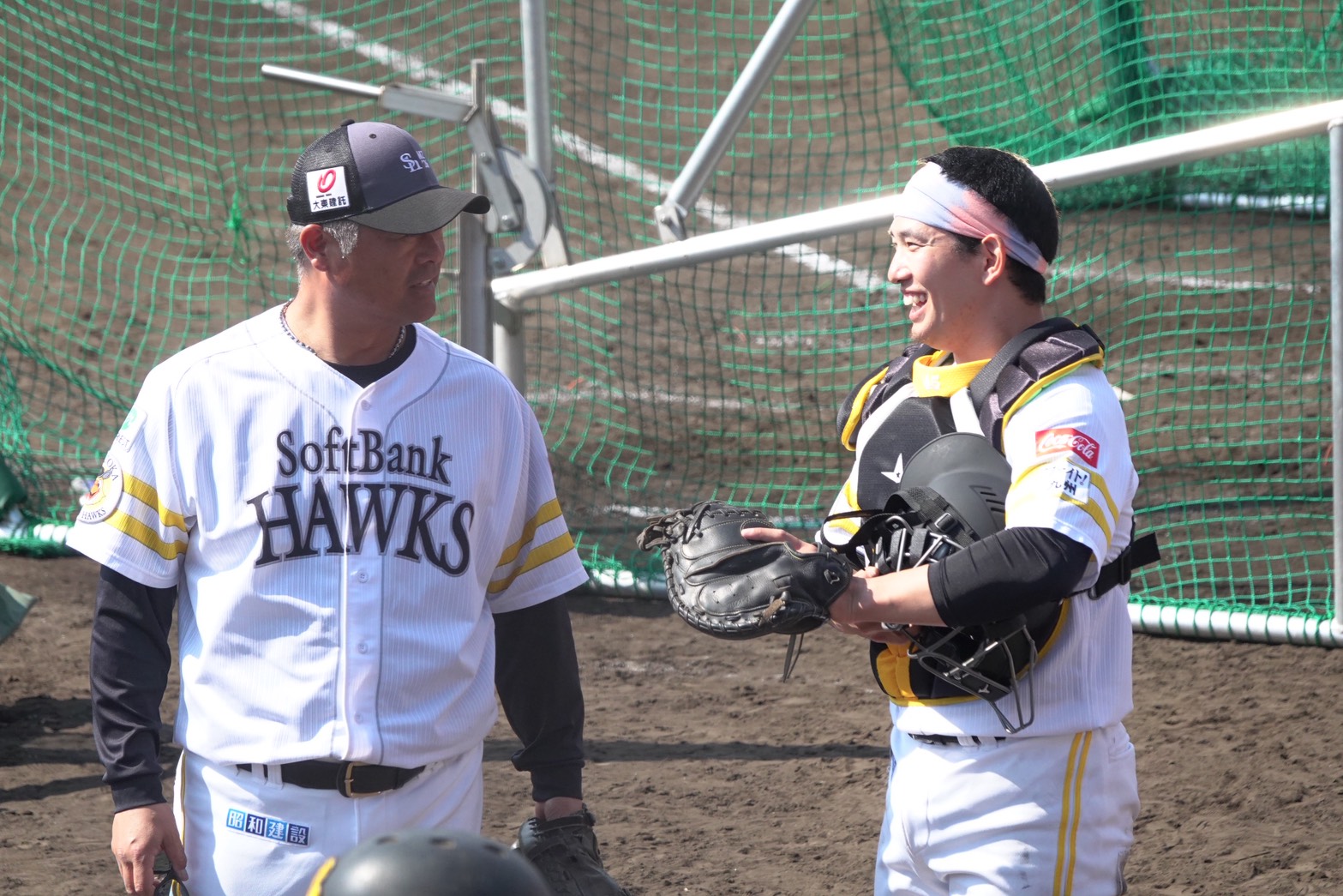 細川亨バッテリーコーチ（左）と会話する栗原陵矢【写真：竹村岳】