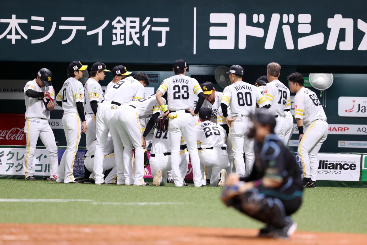 5回の攻撃前、円陣を組むホークスナインと長谷川勇也コーチ【写真：栗木一考】
