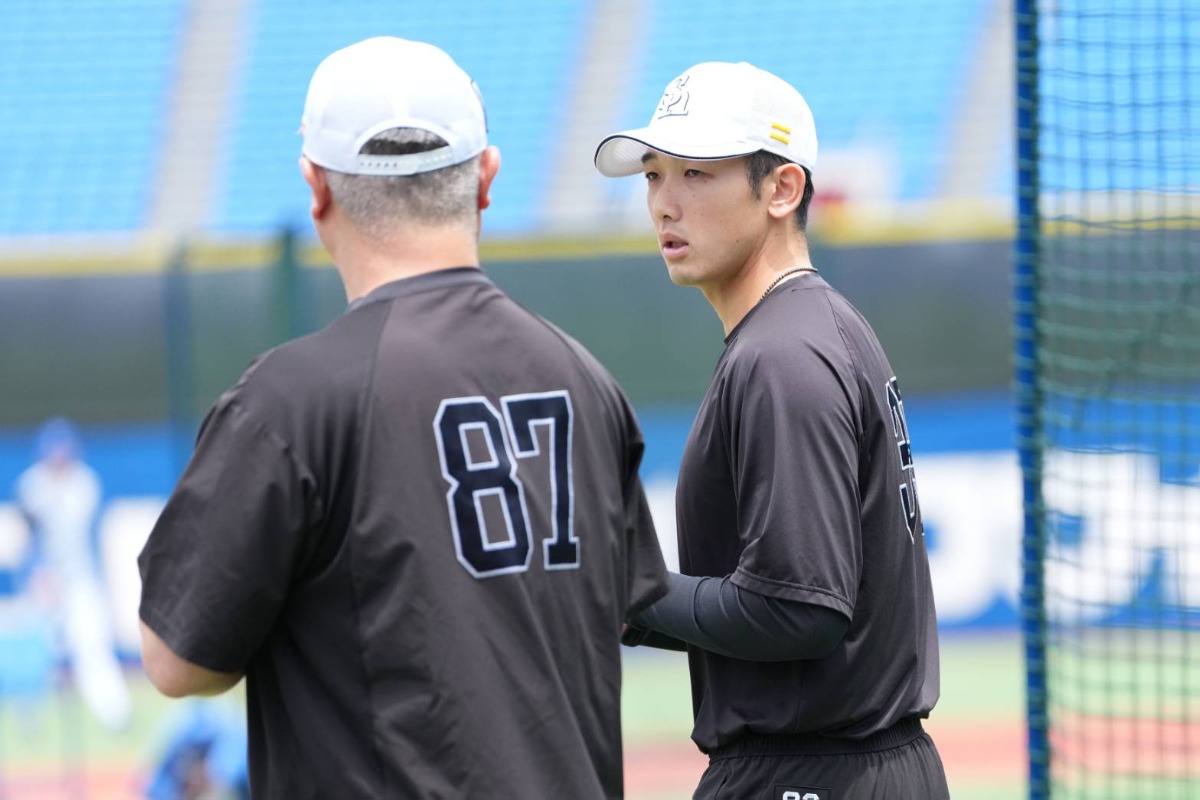 細川亨バッテリーコーチ（左）と話す山本祐大【写真：井上学】