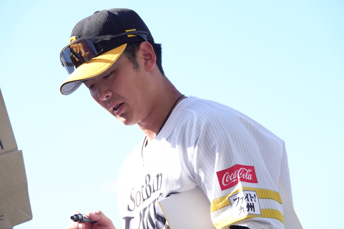 サインを書く石塚綜一郎【写真：竹村岳】