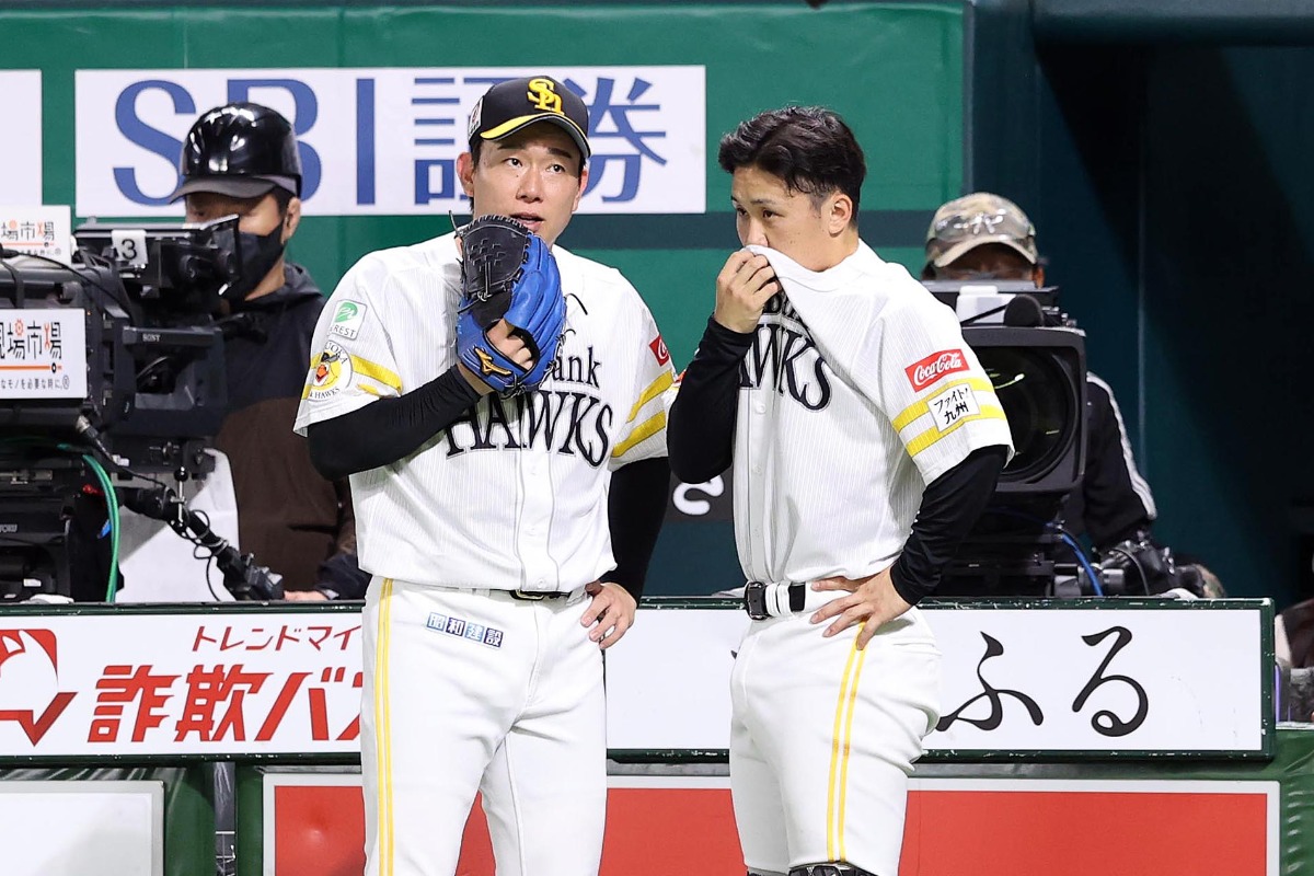 イニング間に会話する中村稔弥（左）と海野隆司【写真：栗木一考】