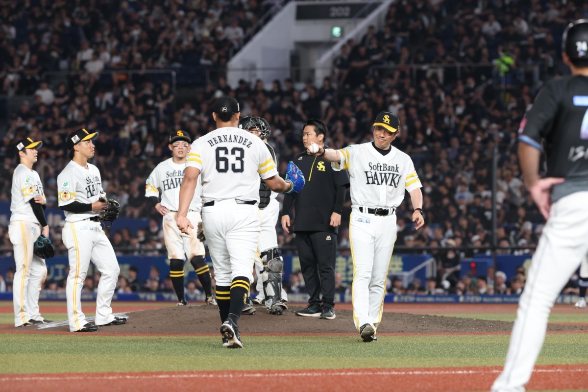 小久保裕紀監督からボールを受け取るダーウィンゾン・ヘルナンデス(左)【写真:栗木一考】