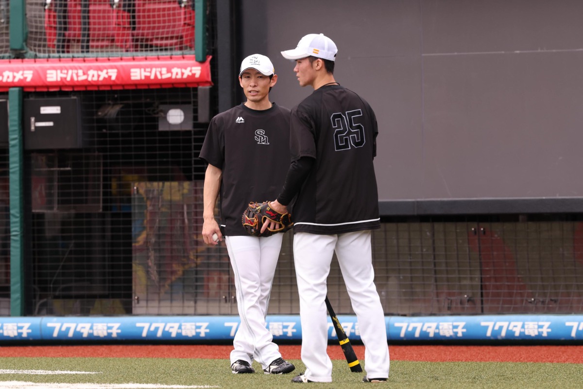 20日の試合前に言葉を交わす本多雄一コーチと庄子雄大【写真:栗木一考】