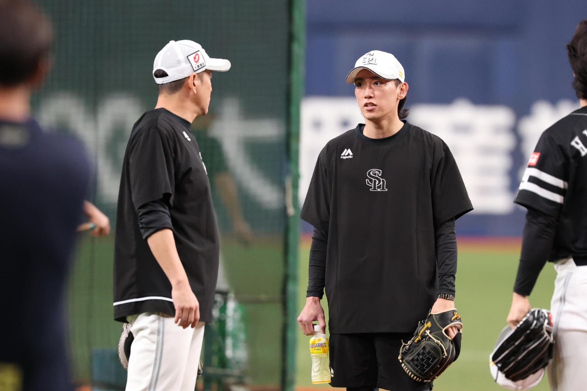 大津亮介(右)と倉野信次投手コーチ【写真:栗木一考】