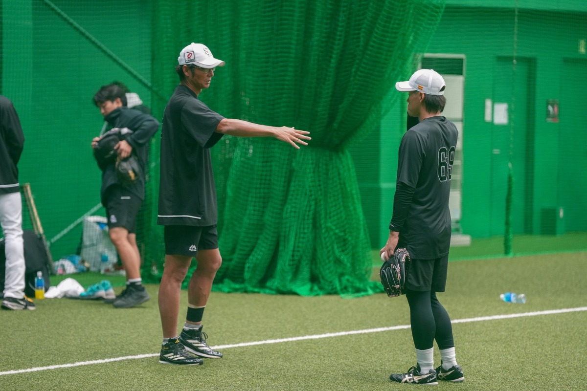 SGLスタジアムの室内練習場で会話する斉藤和巳2軍監督(左)と岩崎峻典【写真:森大樹】